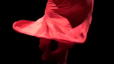 Müziğin ritmine dansçı etek geliştirir. Siyah arka plan. Yakın çekim