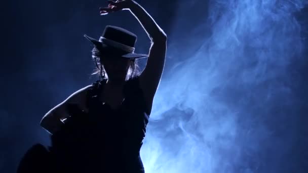 Femme tourne dans une danse incendiaire du flamenco argentin. La lumière par derrière. Fumée de fond. Silhouette — Video