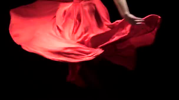 Mujer vestida de rojo realiza movimientos elegantes con las manos en danza. Fondo negro. De cerca. — Vídeo de stock