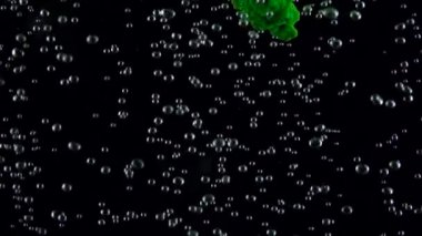 Yeşil boya hava kabarcıkları su altı siyah arka plan üzerine izole. Ağır çekim