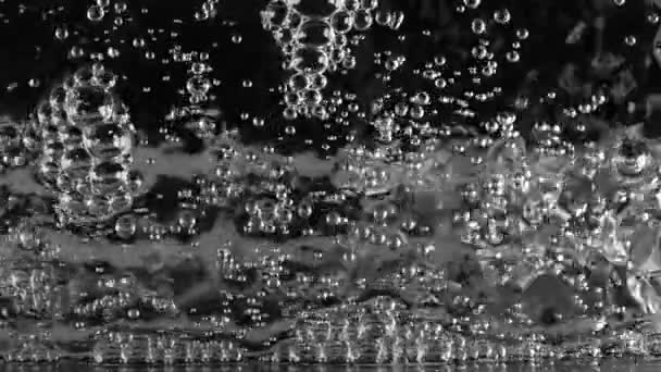 Kokande vatten på svart bakgrund. Slow motion — Stockvideo