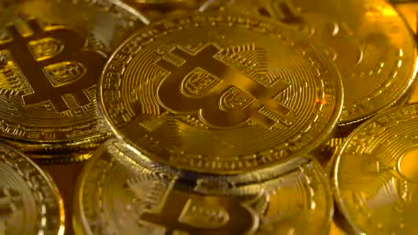 Luxusní zlaté mince jsou že kryptoměn bitcoin se pomalu otáčí v kruhu. Makro snímek rotujícího bitcoinů