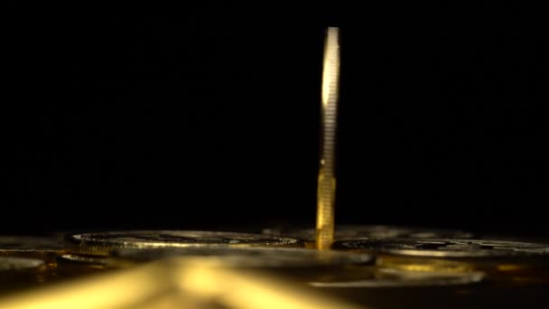 Gouden munten bitcoin cryptocurrencies verschijnen en verdwijnen op een zwarte achtergrond. Close-up — Stockvideo