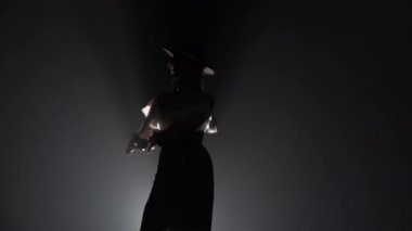 Kız şapka ve kastanyet elinde dans dans ediyor. Arkadan ışık. Duman arka plan. Ağır çekim