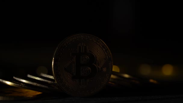 Monedas dinero virtual criptomoneda bitcoin en el crepúsculo en el fondo de oro bokeh. De cerca. — Vídeos de Stock