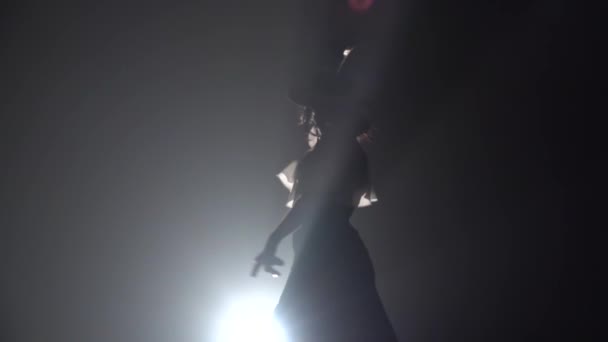 女の子が踊る彼女の手をカスタネットで舞います。後ろからの光。背景を煙します。スローモーション — ストック動画
