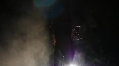 Kız seksi bir dans dans ediyor. Siyah arka plan. Siluet. Ağır çekim