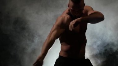 Adam dans etmek kadar seksi bir dans pompalanır. Siyah duman arka plan. Ağır çekim