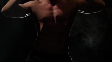 Adam bir striptiz dans ediyor. Siyah arka plan. Ağır çekim