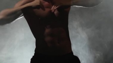 Adam erotik hareketleri dans ediyor. Duman arka plan. Ağır çekim