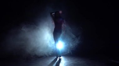 Kız dans seksi dans. siyah duman arka plan. Siluet. Ağır çekim