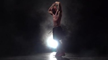 Adam bir striptiz dans ediyor. Siyah arka plan. Ağır çekim