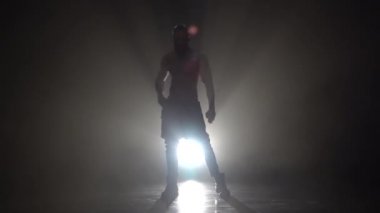 Adam bir striptiz dans ediyor. Siyah arka plan. Ağır çekim