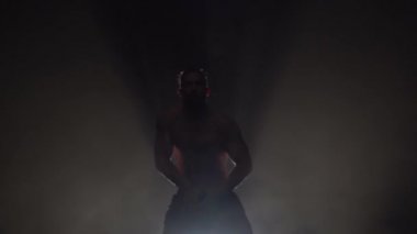 Adam bir striptiz dans ediyor. Siyah arka plan. Siluet. Ağır çekim