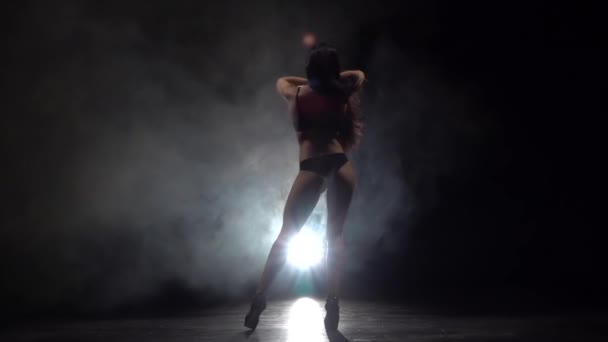 Στριπτιζέζ επαγγελματίας χορεύτρια. Με φόντο μαύρο καπνό. Αργή κίνηση — Αρχείο Βίντεο