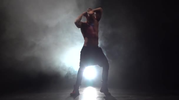 Killen dansar erotiska rörelser. Rök bakgrund. Slow motion — Stockvideo