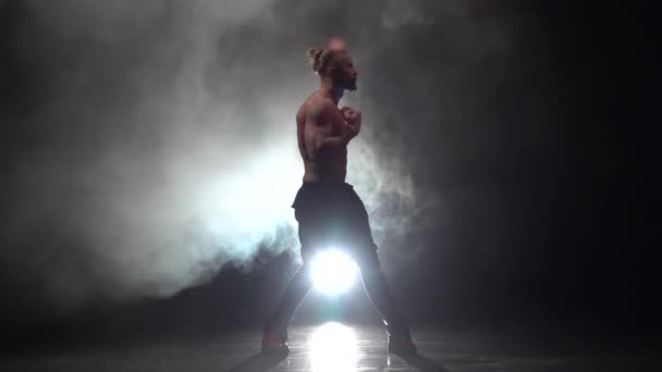 Bebaarde man is een strip met een kale dansen. Rook achtergrond. Slow motion — Stockvideo