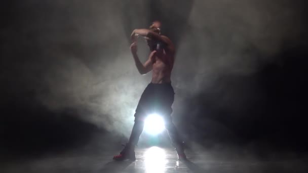 Pumpas upp killen dansar en sexig dans. Svart rök bakgrund. Slow motion — Stockvideo