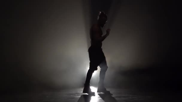 Man is een strip dansen. Zwarte achtergrond. Silhouet. Slow motion — Stockvideo