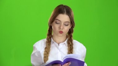 Öğrenci defter görünüyor ve malzeme öğrenir. Yeşil ekran. Ağır çekim