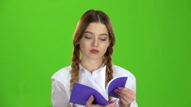 Öğrenci defter görünüyor ve malzeme öğrenir. Yeşil ekran. Ağır çekim