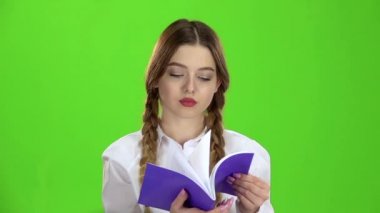 Öğrenci defter görünüyor ve malzeme öğrenir. Yeşil ekran. Ağır çekim