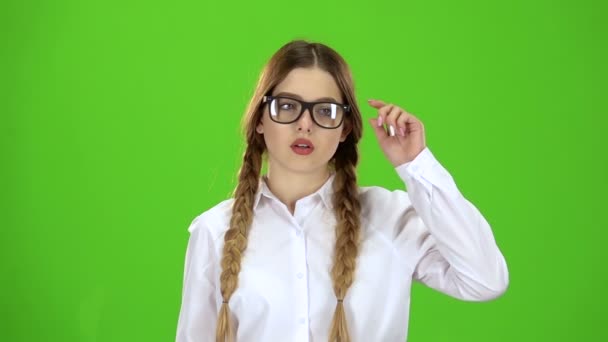 Schoolgirl takes off her glasses, she is tired. Green screen. Slow motion — Stock Video