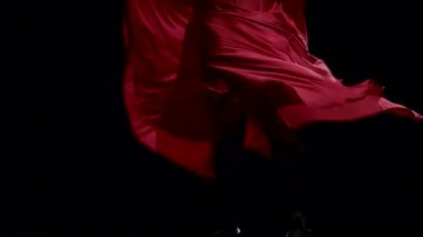 Flamenko. Müziğin ritmine dansçı eteği geliştirir. Siyah arka plan. Yakın çekim. Ağır çekim