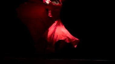 Müziğin ritmine dansçı eteği geliştirir. Siyah arka plan. Yakın çekim. Ağır çekim