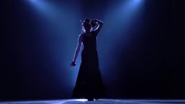 Kız dans onun elinde kastanyet dans ediyor. Arkadan llight. Duman arka plan. Siluet. Ağır çekim