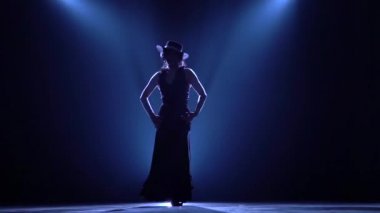 Kız dans onun elinde kastanyet dans ediyor. Arkadan llight. Duman arka plan. Siluet. Ağır çekim