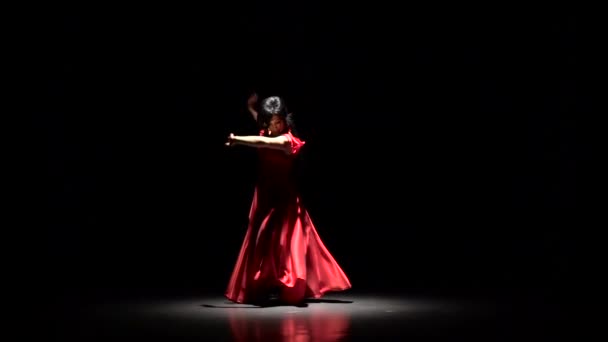 Dívka v šatech tmavé místnosti provádí elegantní pohyby rukama v tanci. Černé pozadí. Zpomalený pohyb — Stock video