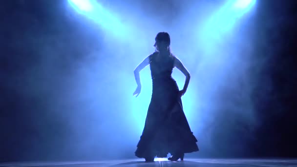 Danseres in een chique jurk in een brandbommen dans van de flamenco. Llight van achteren. Rook achtergrond. Silhouet. Slow motion — Stockvideo