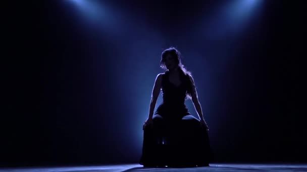 Mädchen tanzt in einem dunklen Raum mit anmutigen Handbewegungen. Das Licht von hinten. Rauchentwicklung. Silhouette. Zeitlupe — Stockvideo