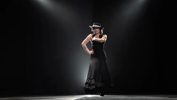 Menina dançando uma dança incendiária espanhola. Fundo preto. Luz por trás. Movimento lento — Vídeo de Stock