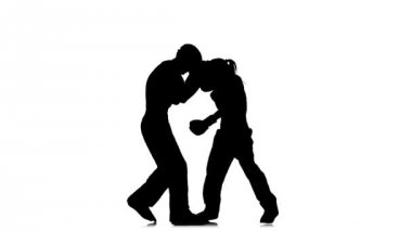 Adam kask ve kickboxing eldiven ringde yenerek bir kızla. Siluet. Beyaz arka plan