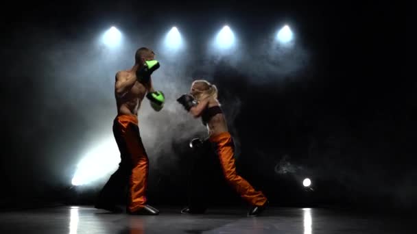 Boy fight and girl on boxing paws. Light from behind. Smoke background — Stock Video