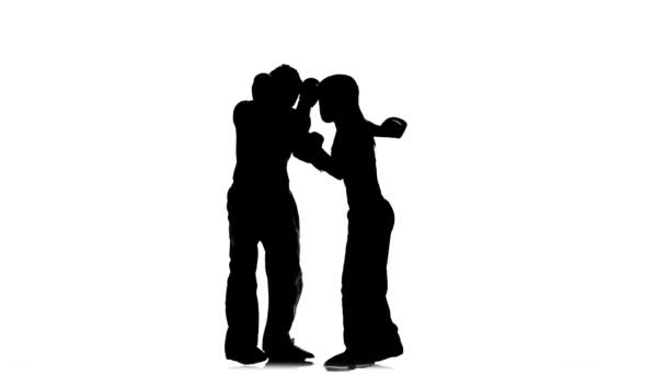 Hombres con una chica en cascos y guantes de boxeo latiendo en el ring. Silueta. Fondo blanco — Vídeo de stock