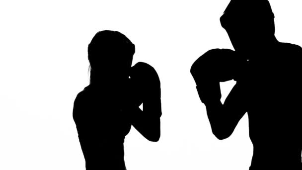 Mädchen kickt den Kerl, den sie zum Kickboxen einladen. Silhouette. weißer Hintergrund — Stockvideo