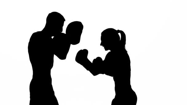 Bout killen och tjejen på boxning tassar. Siluett. Vit bakgrund — Stockvideo