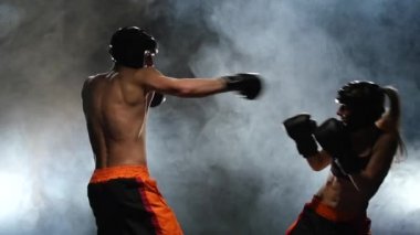 Kız boksör bir adam tarafından çalıştırıldılar. Boks ringde fikir tartışması. Ağır çekim. Duman arka plan