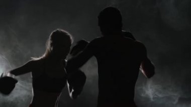 Adam ve boks gurl. Arkadan ışık. Siluet. Duman arka plan. Ağır çekim