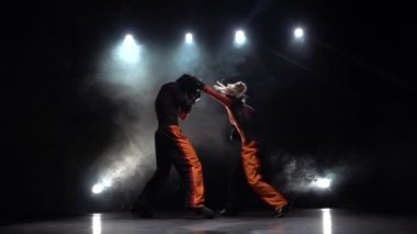 Kadın kickboxing için fikir tartışması adam tekme. Duman arka plan. Ağır çekim. Arkadan ışık