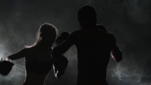 Guy e la ragazza sulla boxe. Luce da dietro. Silhouette. Sfondo di fumo. Rallentatore — Video Stock