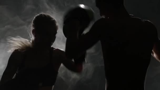 男とボクシングの女の子。後ろからの光。シルエット。背景を煙します。スローモーション — ストック動画