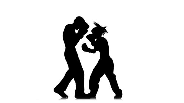 Kickboxer girl chuta na cabeça de um adversário. Silhueta. Fundo branco. Movimento lento — Vídeo de Stock