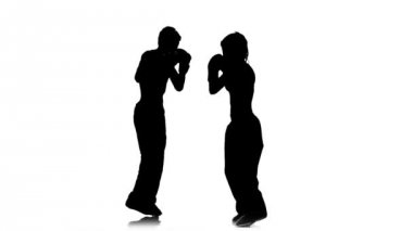 Kız kickboks için fikir tartışması adam vuruyor. Siluet. Beyaz arka plan. Ağır çekim