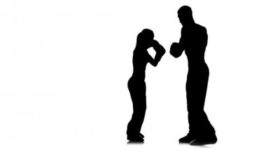 Kickboks boks pençeleri üzerinde kız ayakları adam tutar onları yener. Siluet. Beyaz arka plan