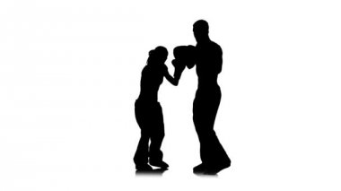 Kickboks boks pençeleri üzerinde kız ayakları adam tutar onları yener. Siluet. Beyaz arka plan