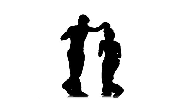 Kickboxer girl kicks on the head of an opponent. Silhouette. White background. Slow motion — Stock Video